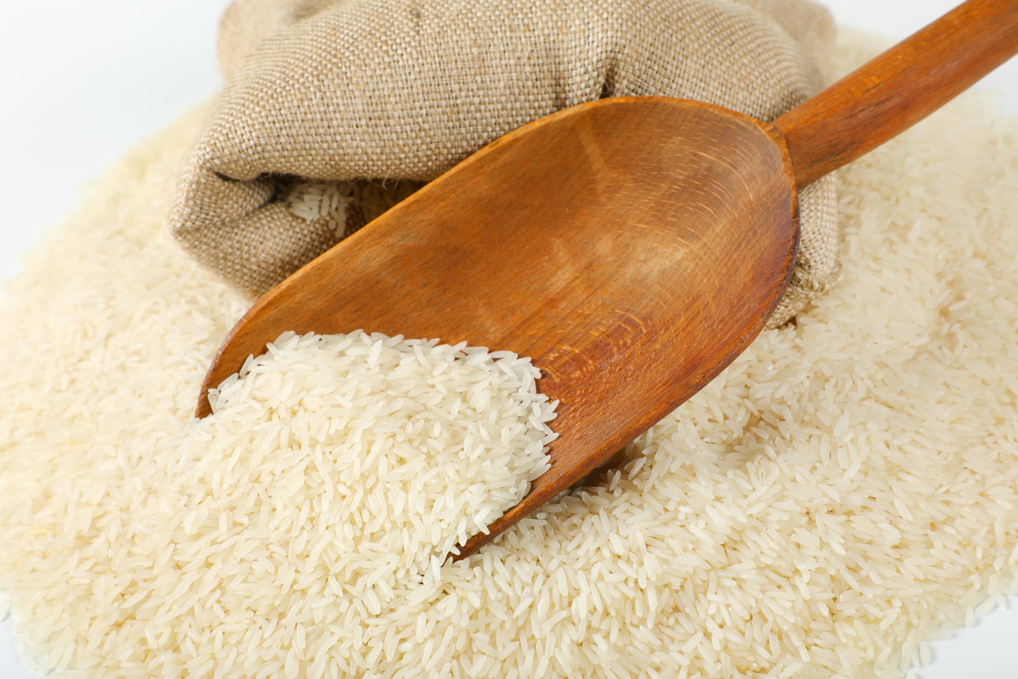 long grained rice, wooden scoop and burlap bag